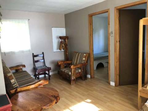 The La Loutre chalet living room features rustic wooden furniture for a comfortable stay.