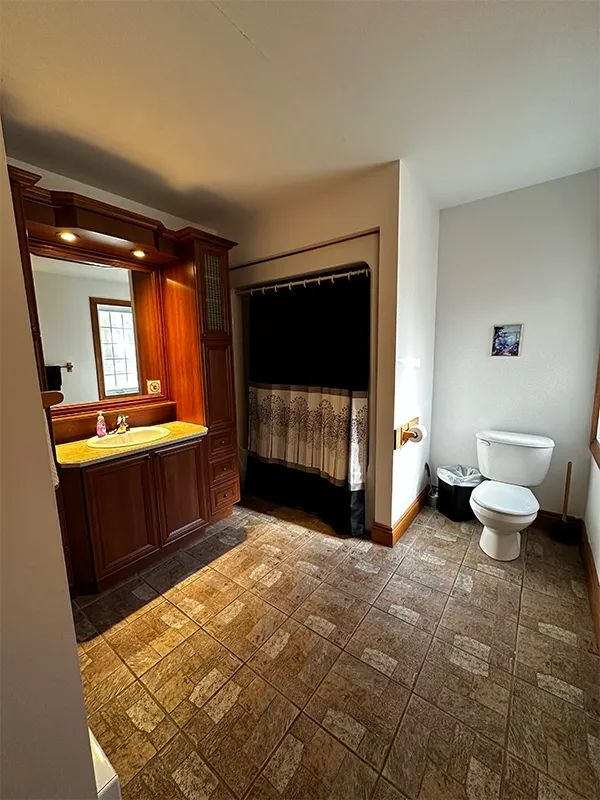 The bathroom in the Grizzly cottage features a shower and a wooden vanity.