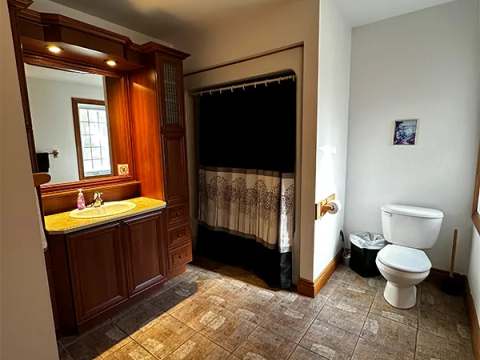 The bathroom in the Grizzly cottage features a shower and a wooden vanity.