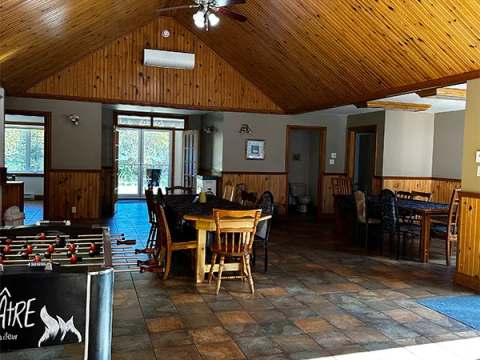 The open area of the cottage features a dining table and a foosball table.