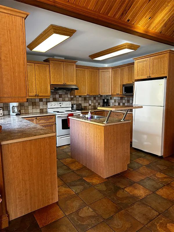 The cabin's equipped kitchen features a central island, wooden cabinets, and appliances.