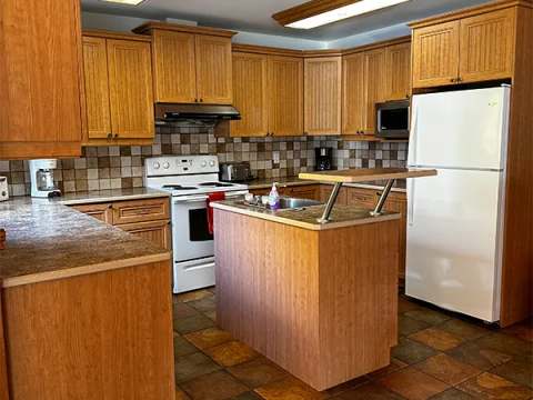 The cabin's equipped kitchen features a central island, wooden cabinets, and appliances.