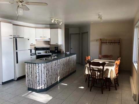 The functional kitchen and dining area of the Le Pékan chalet offer a friendly living space.