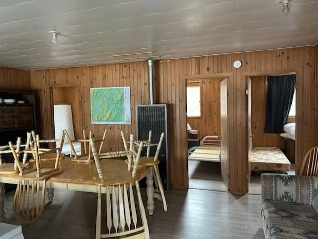 Vue d'ensemble de l'aire commune du chalet Renard avec table à manger et accès aux chambres.