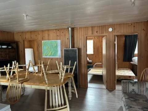 Vue d'ensemble de l'aire commune du chalet Renard avec table à manger et accès aux chambres.