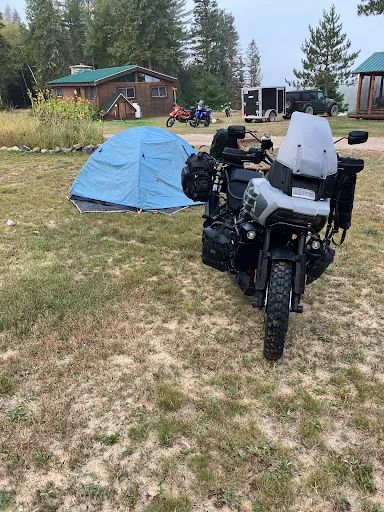 Vue sur le site de la pourvoirie avec chalet et espaces de camping pour les motocyclistes.
