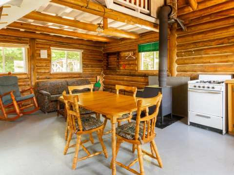 Open living area featuring a dining table, a seating area, and a wood stove.