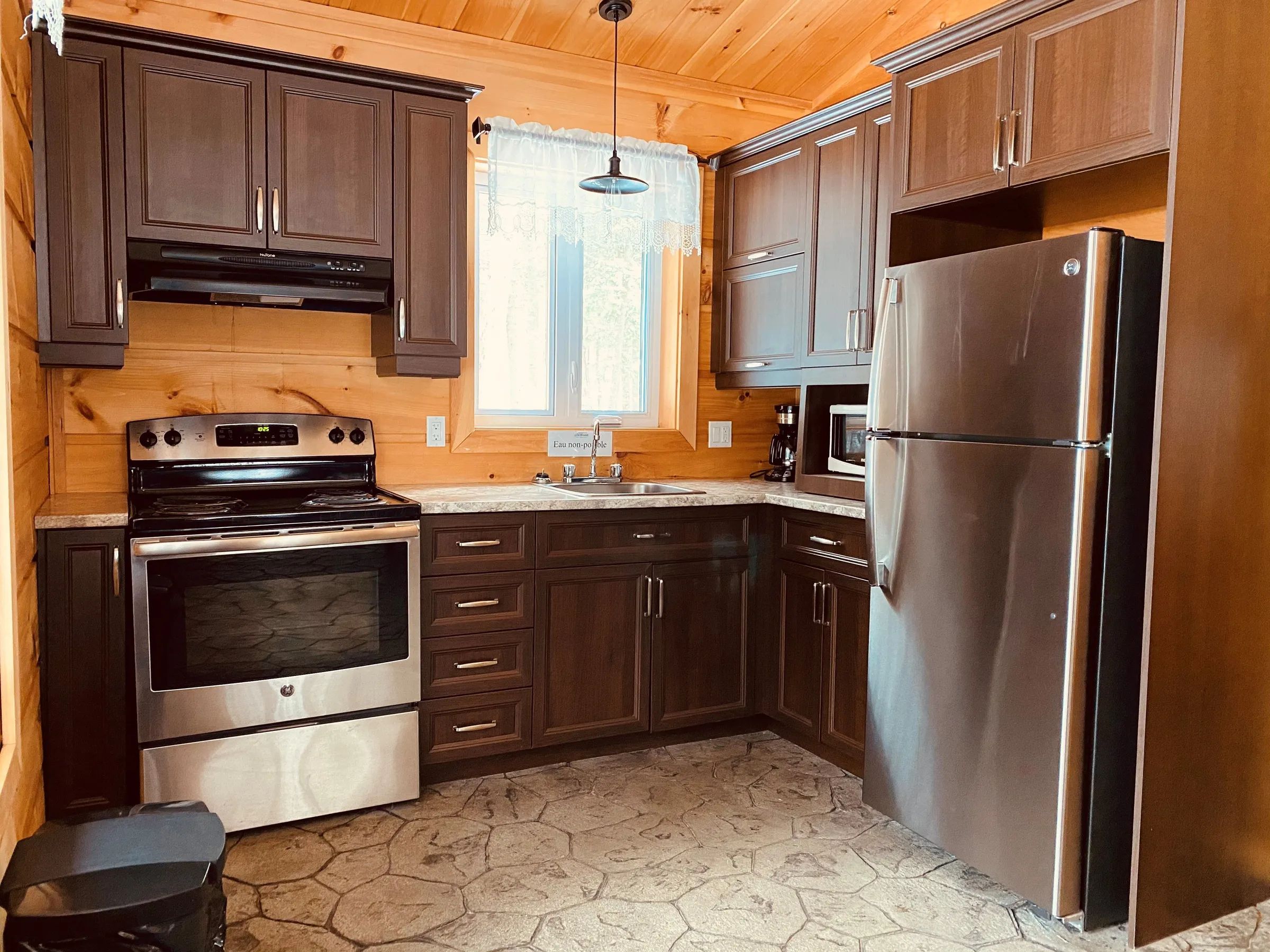 The equipped kitchen of the Chalet des Loutres features stainless steel appliances.