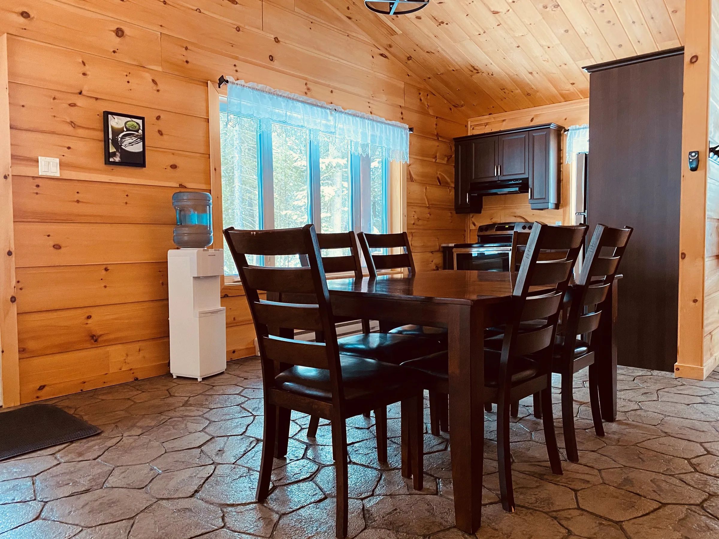 The cottage dining room features a wooden table and a functional kitchen.