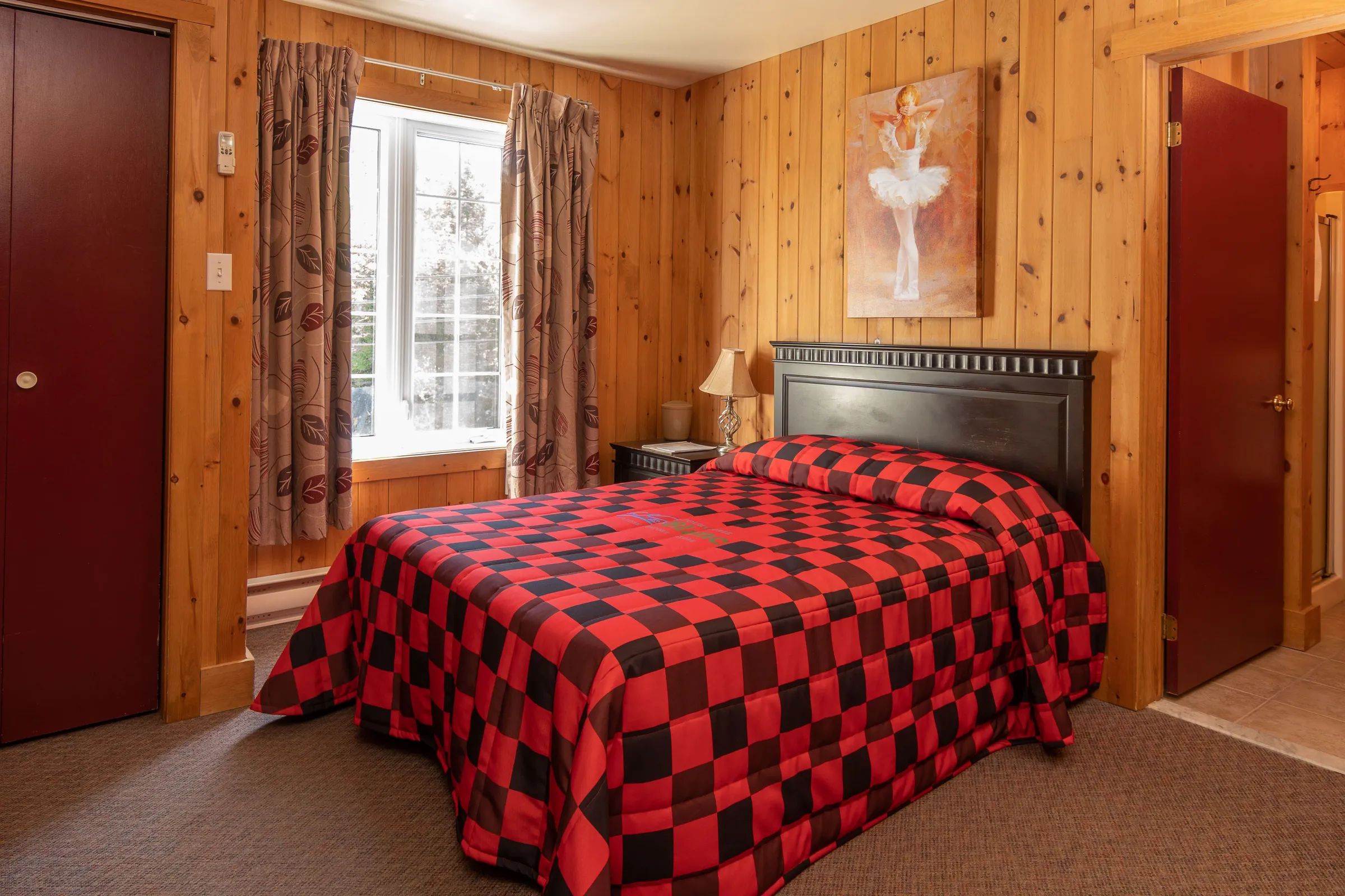 This classic room features a double bed and decor with warm wood walls.