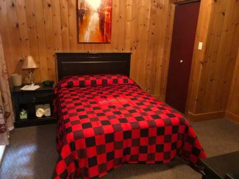 This classic room features a cozy bed with a red and black plaid bedspread.