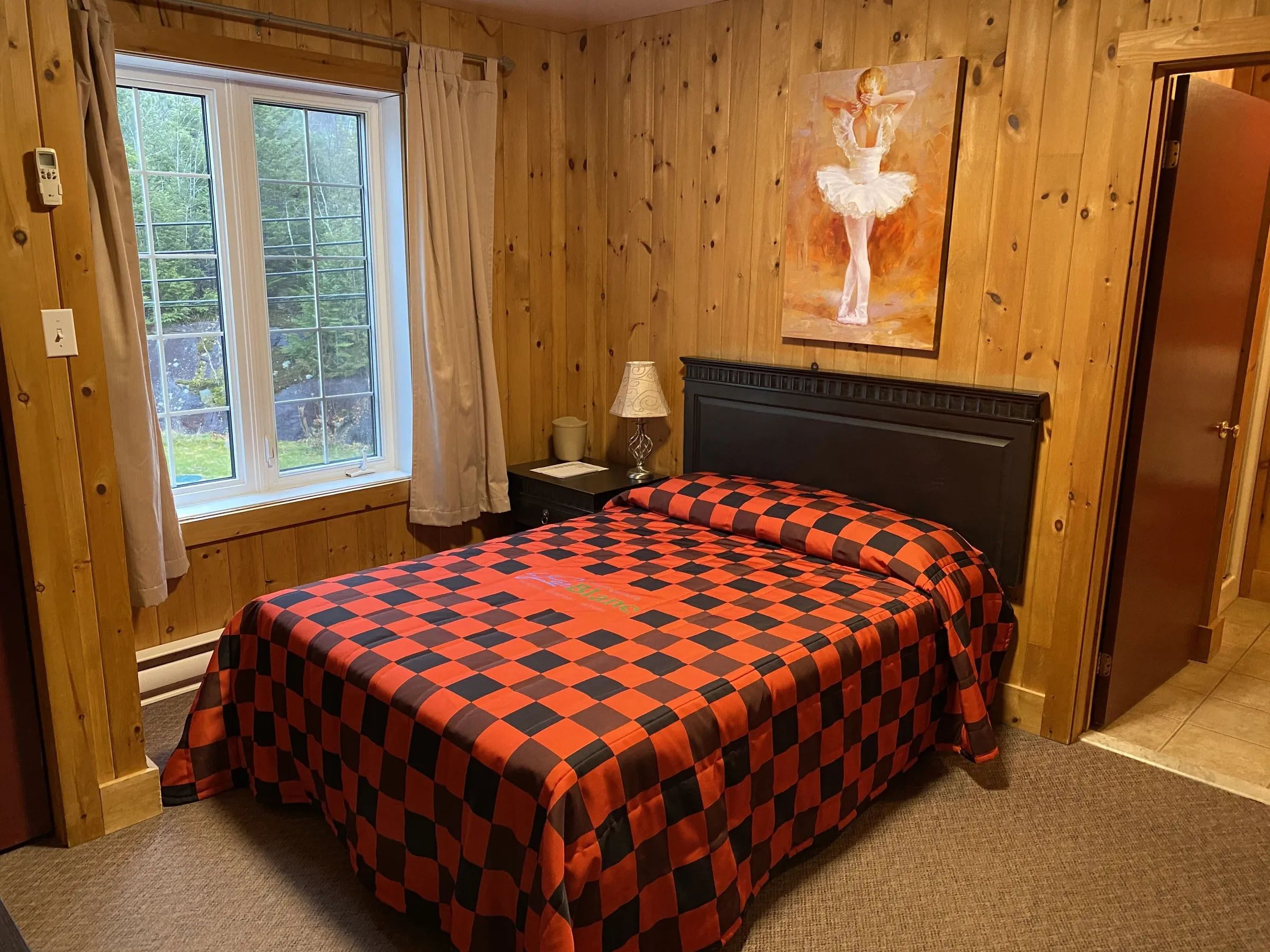 This classic room features a double bed and warm wood paneling decor.