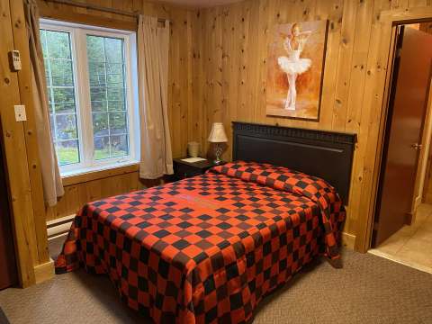 This classic room features a double bed and warm wood paneling decor.