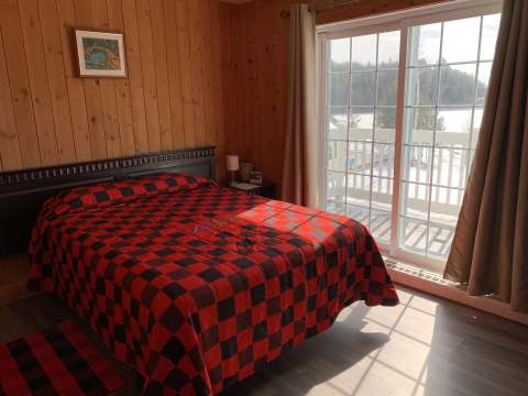 Classic bedroom with a bed and a sliding door leading to an outdoor balcony.