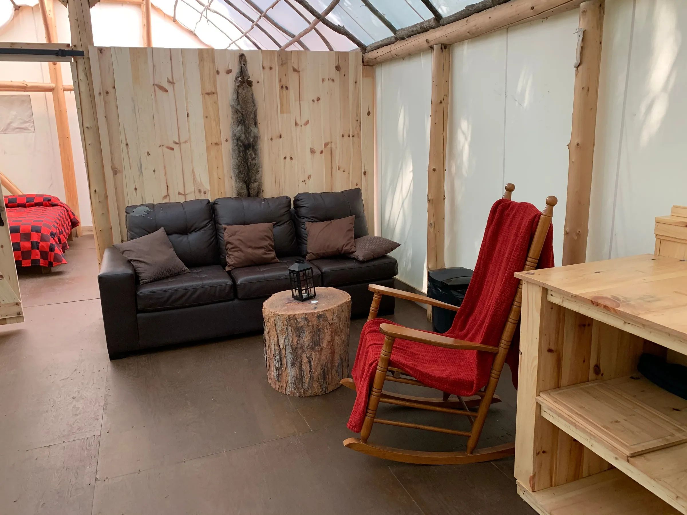Le salon du prêt-à-camper comprend un canapé, une chaise berçante et une table basse rustique.