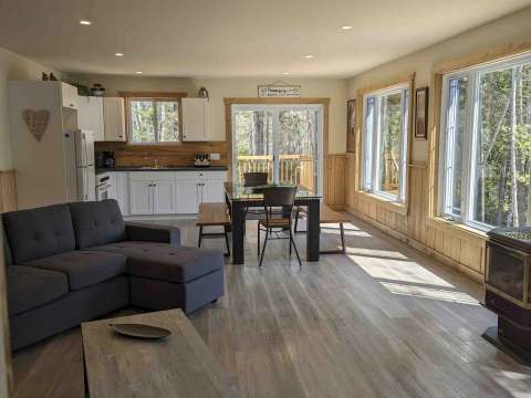 The open area of the cabin includes a functional kitchen, a dining table, and a comfortable living room.