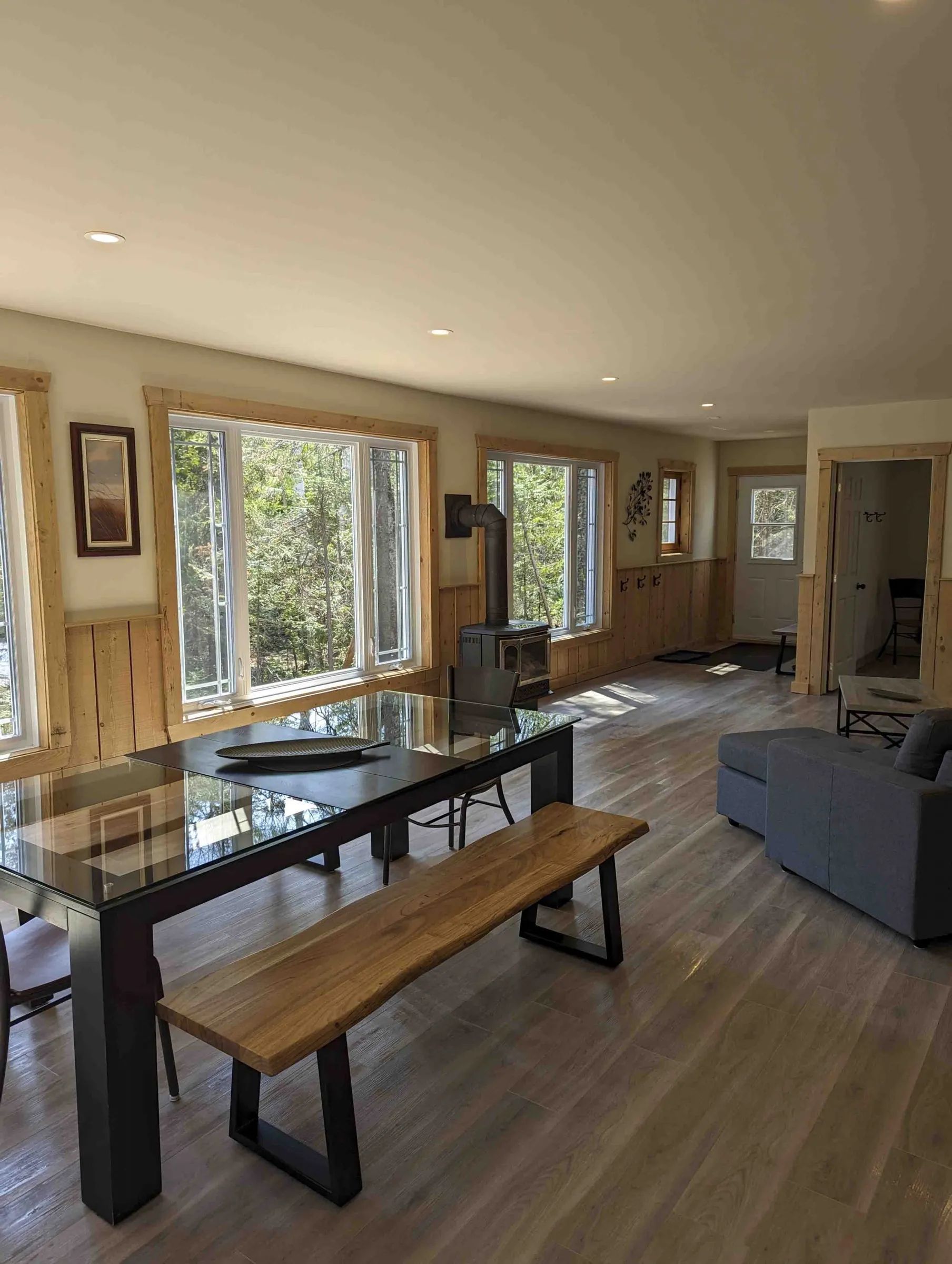 The living area of the Canard chalet includes a dining table and a wood stove.