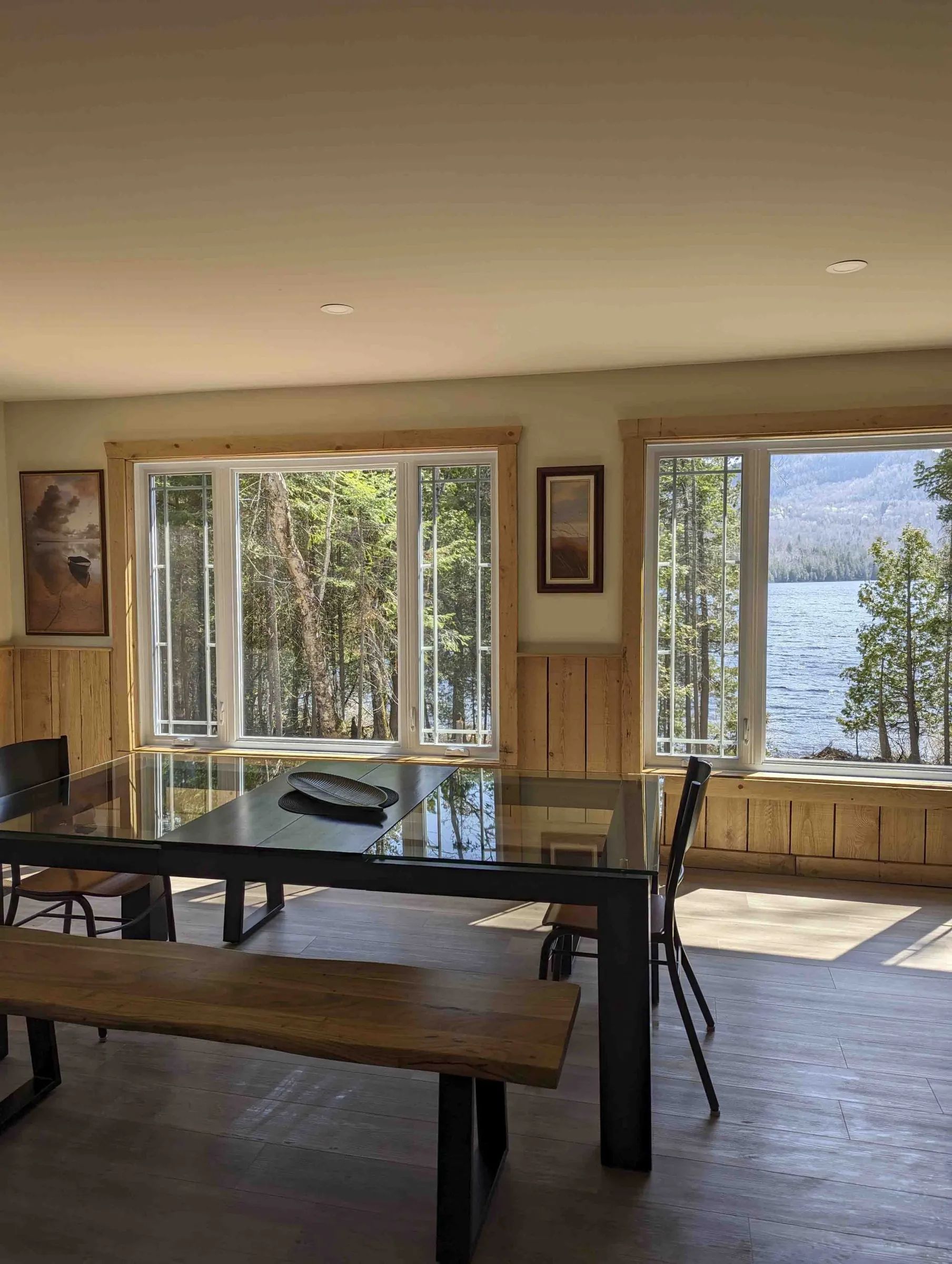 The cottage dining room offers an open view of the lake and the surrounding forest.