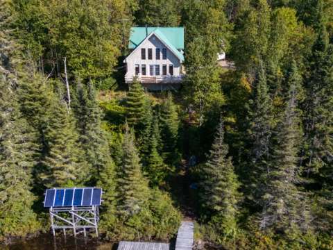 Vue aérienne du Chalet du Grand Héron et de son quai privé au bord de l'eau.