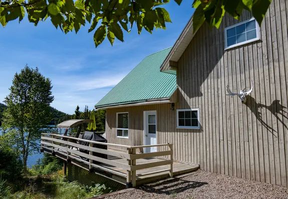 Vue latérale du Chalet du Grand Héron avec sa galerie et sa vue sur le lac.