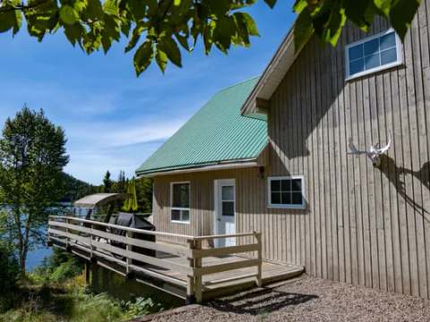 Vue latérale du Chalet du Grand Héron avec sa galerie et sa vue sur le lac.