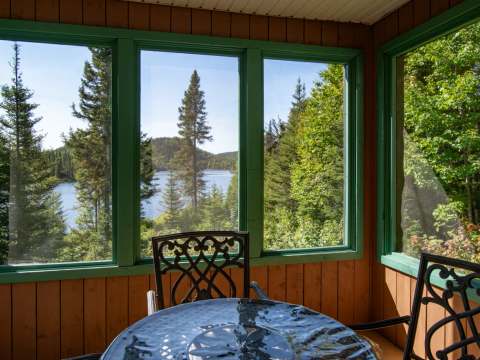 Profitez d'une vue sur le lac depuis la véranda fermée du chalet.