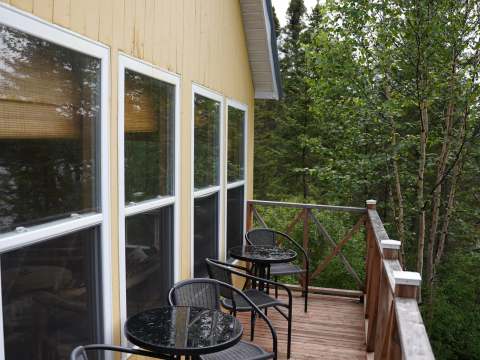 La galerie extérieure du Chalet de l'Ours est aménagée avec des tables et des chaises.