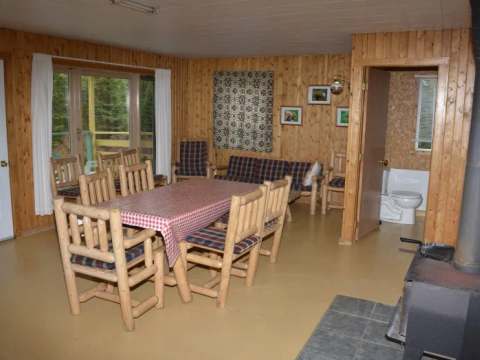 La salle à manger et le salon du Chalet du Bûcheron avec son poêle à bois.