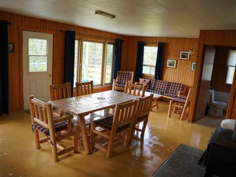 L'aire ouverte du chalet comprend une table à manger, un salon confortable et une cuisine.