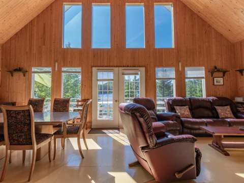 L'aire ouverte du chalet dispose d'une salle à manger et d'un salon avec vue sur le lac.