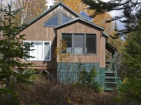 Le chalet du Grand Héron est situé en bordure de lac, entouré d'une forêt dense et mature.