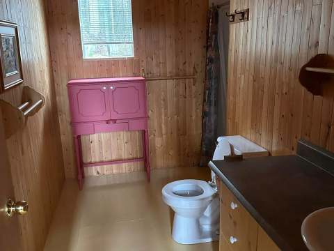 Le chalet du Huard est entouré d'arbres et dispose d'une grande terrasse en bois.