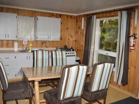 La cuisine et la salle à manger fonctionnelles du Chalet du Huard incluent une table et quatre chaises.