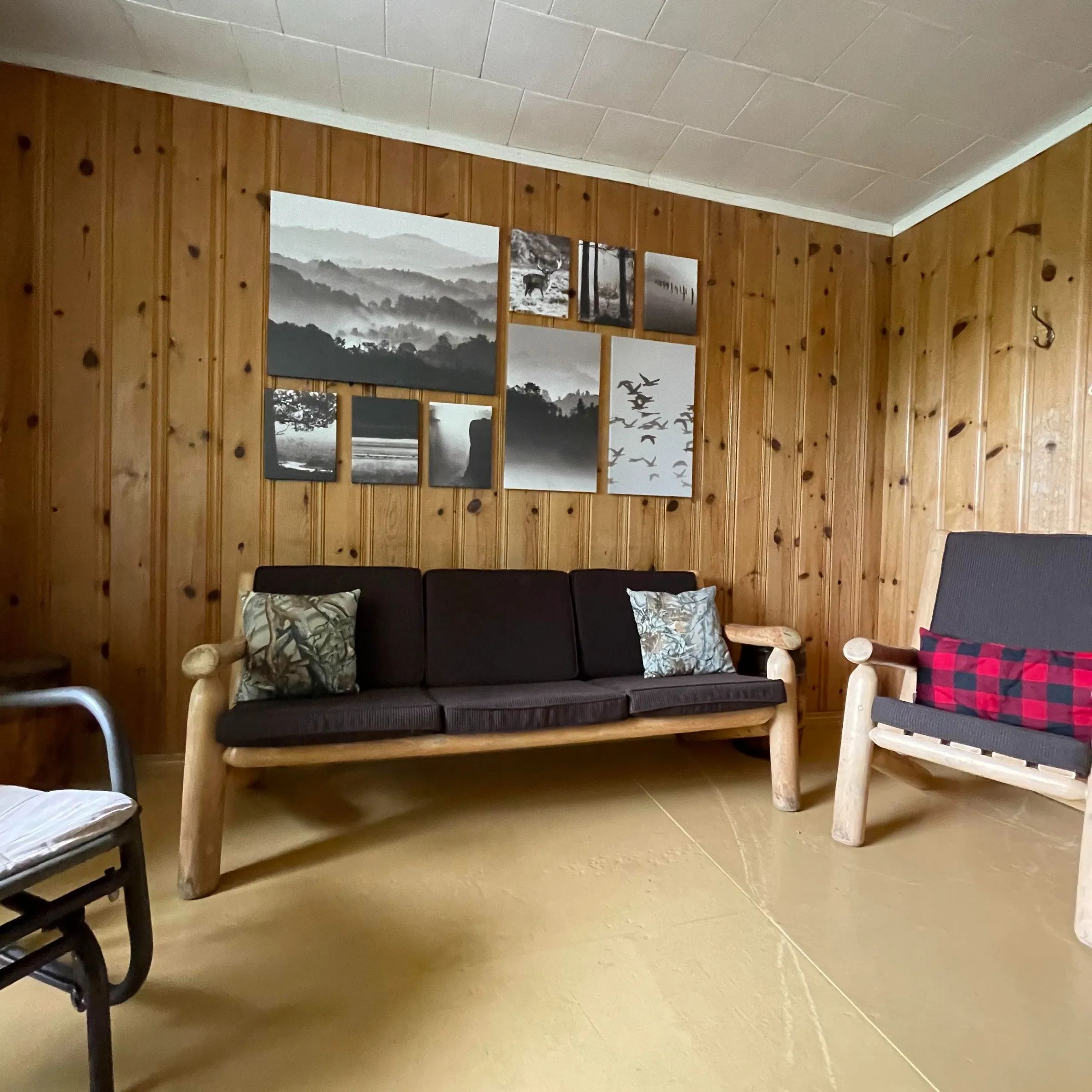 Le salon du chalet dispose de sièges en bois et d'une décoration murale thématique.