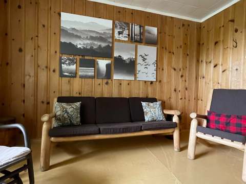Le salon du chalet dispose de sièges en bois et d'une décoration murale thématique.