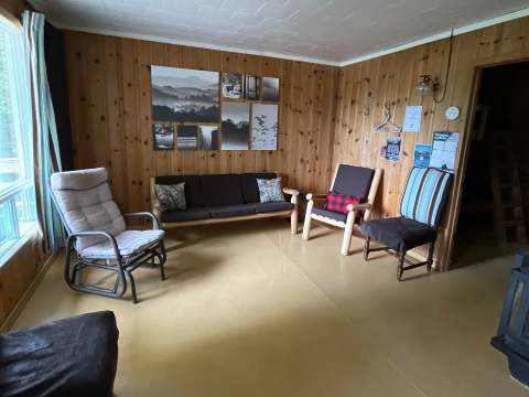 Le salon du chalet offre un espace de détente avec des sièges en bois et une décoration rustique.