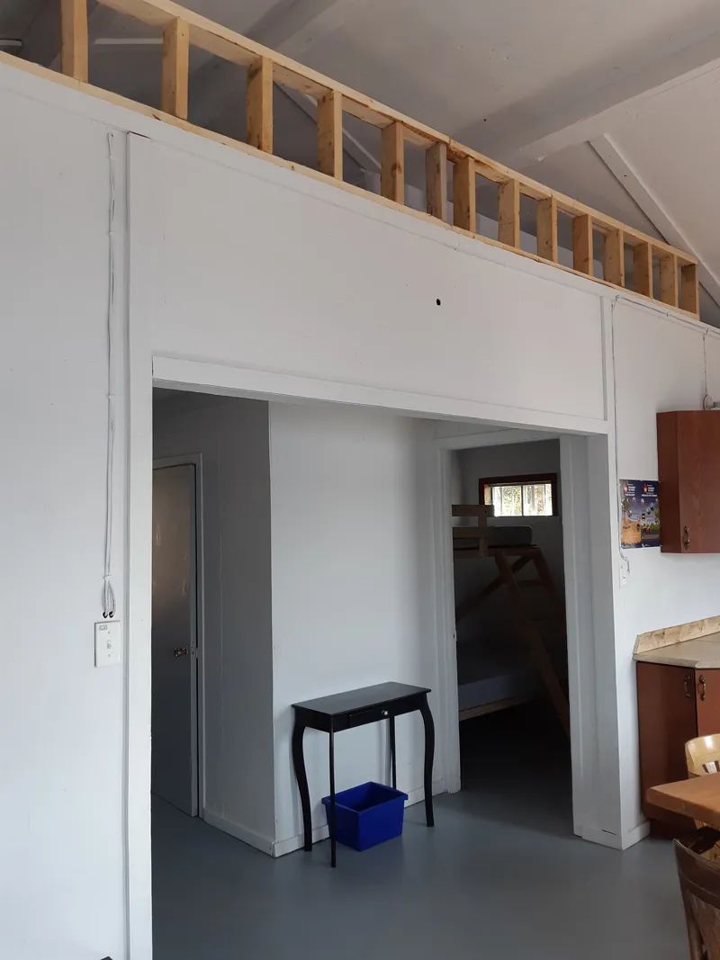 Interior view of the kitchen open to the bedroom of the cabin.