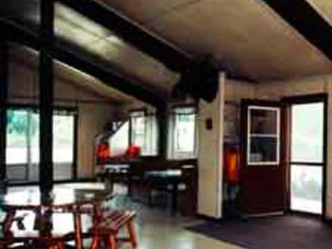 Interior view of the Pavillon Sud living area with dining table and outdoor access.