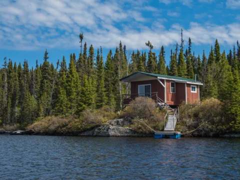 Chalet 2 is located at the water's edge with direct access via stairs and a small dock.