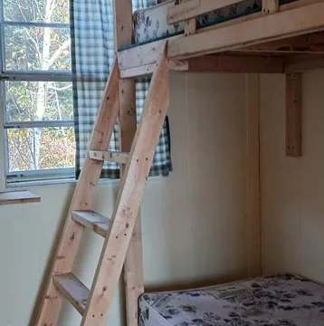 A wooden bunk bed is set up in the cottage bedroom.