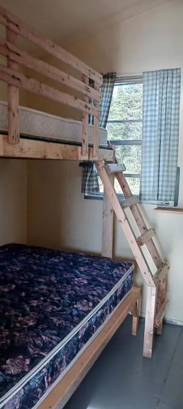 A wooden bunk bed is set up in the cottage bedroom.