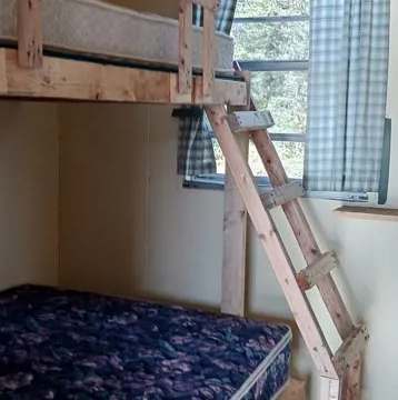 A wooden bunk bed is set up in the cottage bedroom.