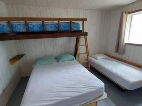 Cette chambre dispose d'un lit superposé et d'un lit simple pour accommoder les invités.