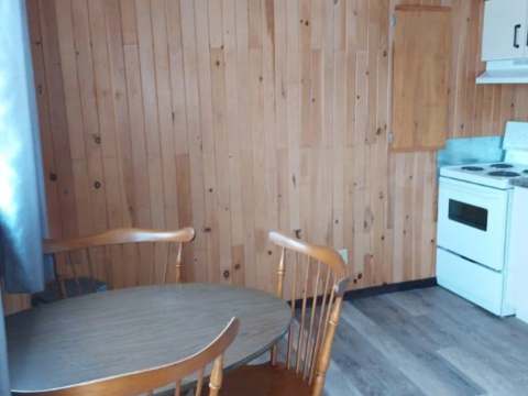 La cuisine du chalet comporte une table avec des chaises en bois.