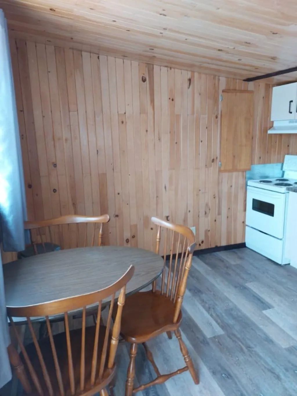 La cuisine du chalet comporte une table avec des chaises en bois.