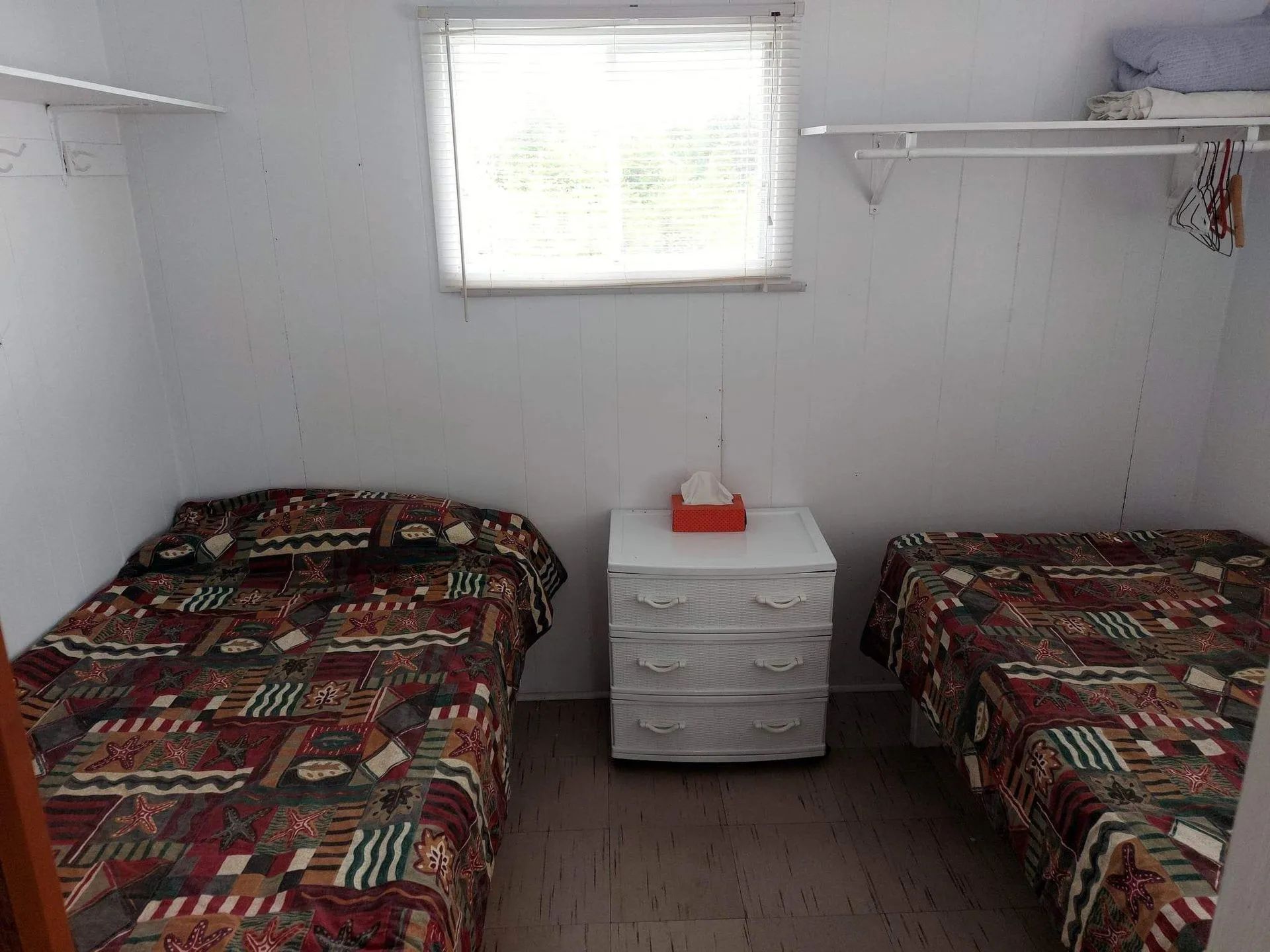 Cette chambre du chalet Pimbina est aménagée avec deux lits simples et une table de chevet.
