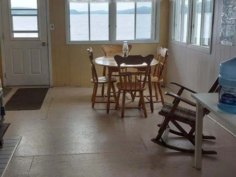 View of the Pimbina cabin's living area including a dining table and a wood stove.