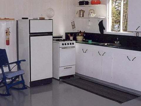 The chalet's functional kitchen includes a stove, a refrigerator, and storage space.