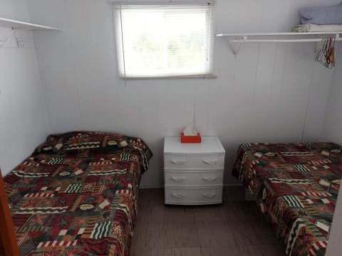 This bedroom in the Pimbina cabin is furnished with two single beds and a nightstand.