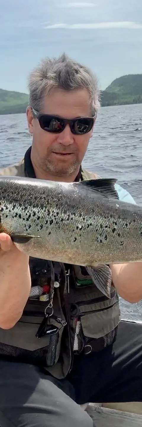 Pêcheur présentant une ouananiche capturée au Lac Holt chez Pourvoirie du Lac Holt, Côte-Nord, Québec